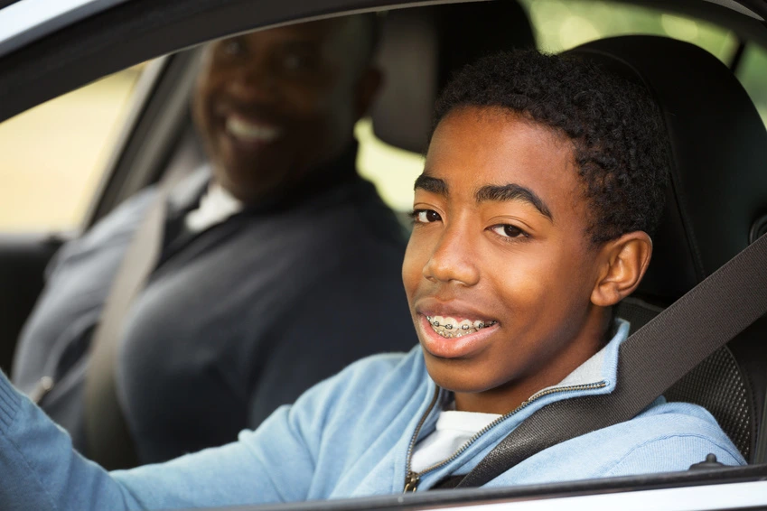 african american teen learning to drive with mom