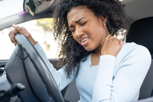 Woman Experiencing Whiplash Injury in Car