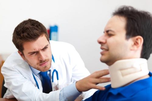 Atlanta injury clinic doctor inspects a patient's neck