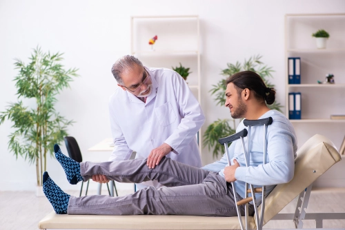 Atlanta injury doctor checks his patient's leg
