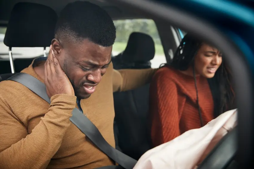 Person experiencing headache after car accident that may indicate a concussion