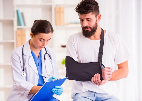 accident doctor or family doctor helping man with broken arm