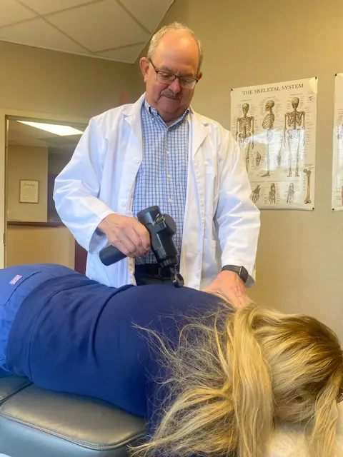 Chiropractor relieving shoulder pain for patient