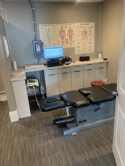Chiropractor's office with table, posters, and counter