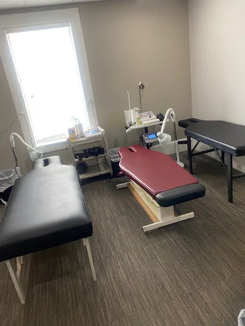3 Chiropractor tables in a room with a big window