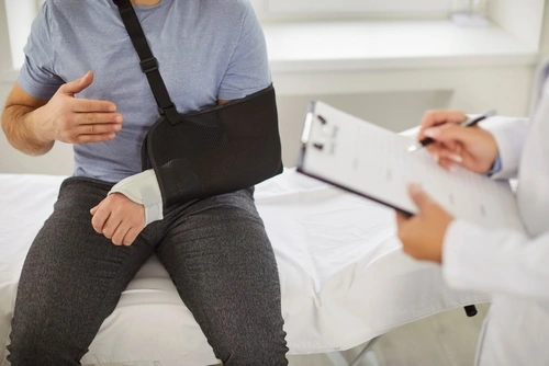 A Marietta car accident doctor talks to a man with a broken arm.